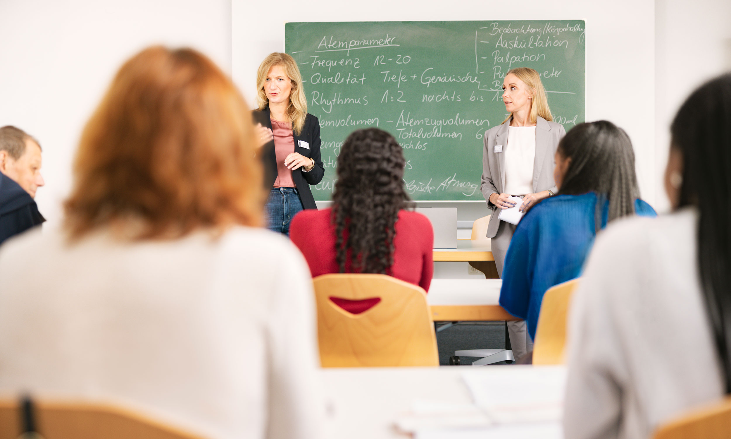 Schulungssituation zwei Lehrkrfte und vier Auszubildende an einer Tafel