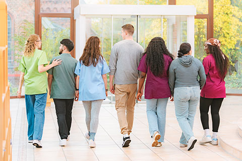 Sieben Auszubildende auf dem Weg aus der Pflegeschule